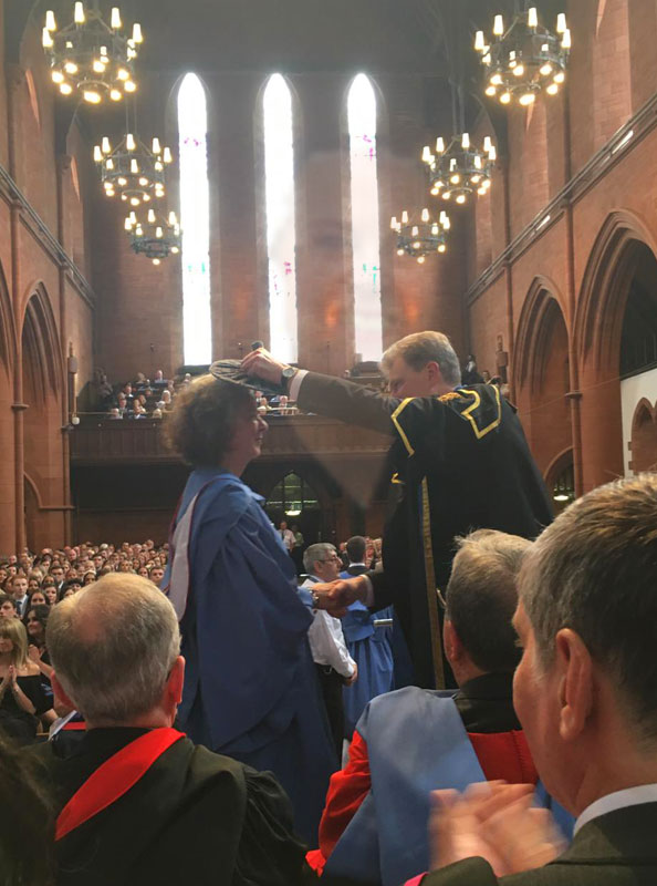 A man is being handed the crown by a woman.
